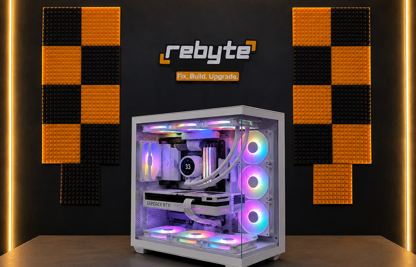 A custom gaming PC built by Rebyte, lit up in front of the Rebyte workshop wall